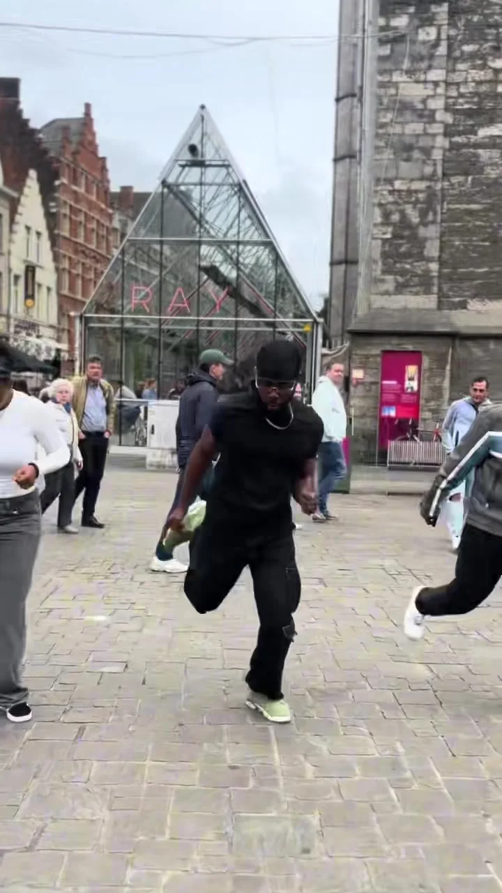 Go Church members dancing on the Korenmarkt in Ghent while shoppers look on.