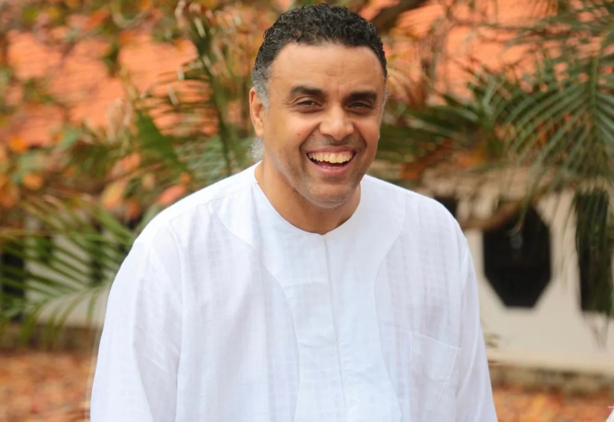 Bishop Dag Heward-Mills smiling, in white, outdoors.